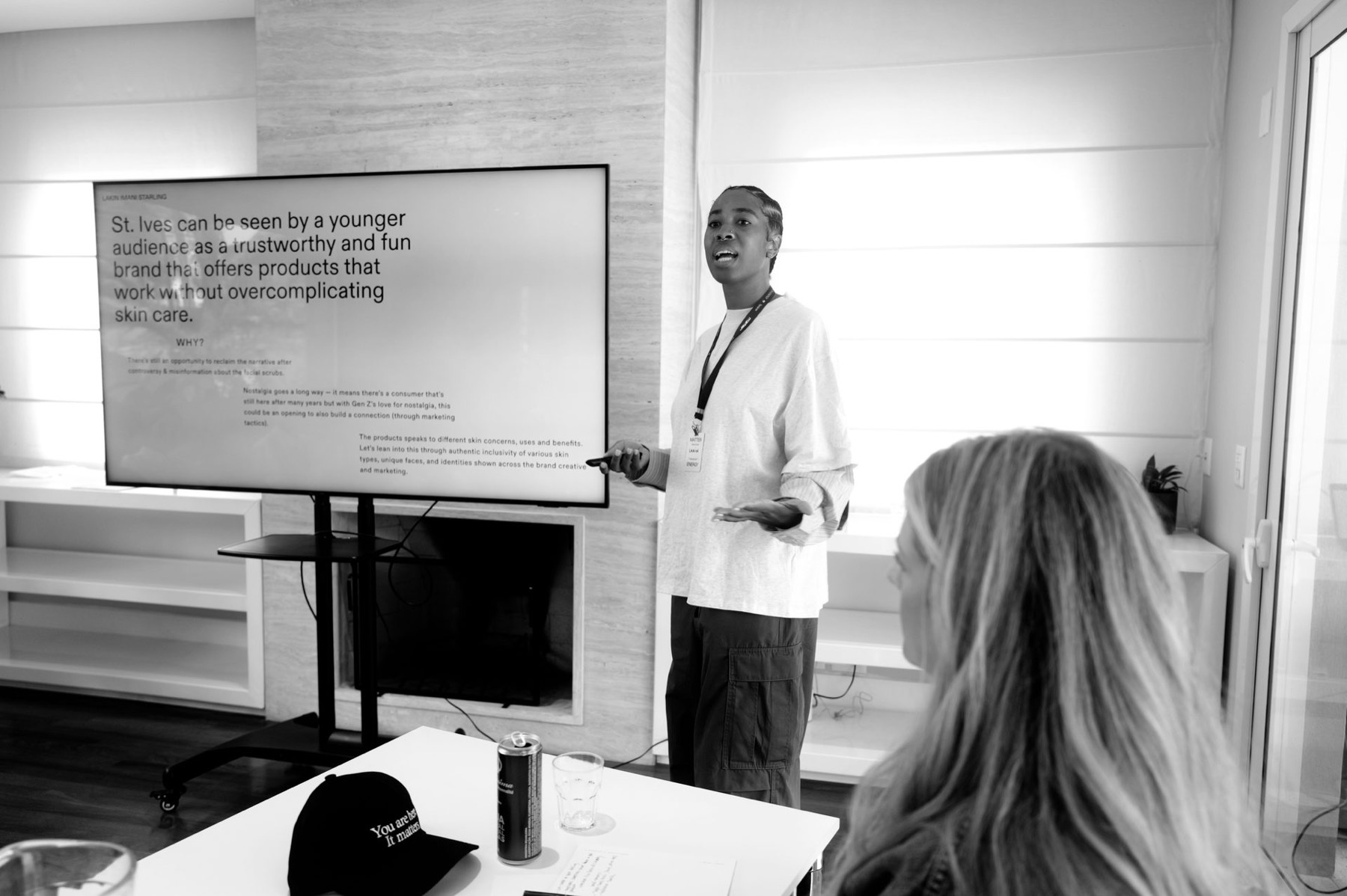 A strategist presenting work on a screen, the room listening