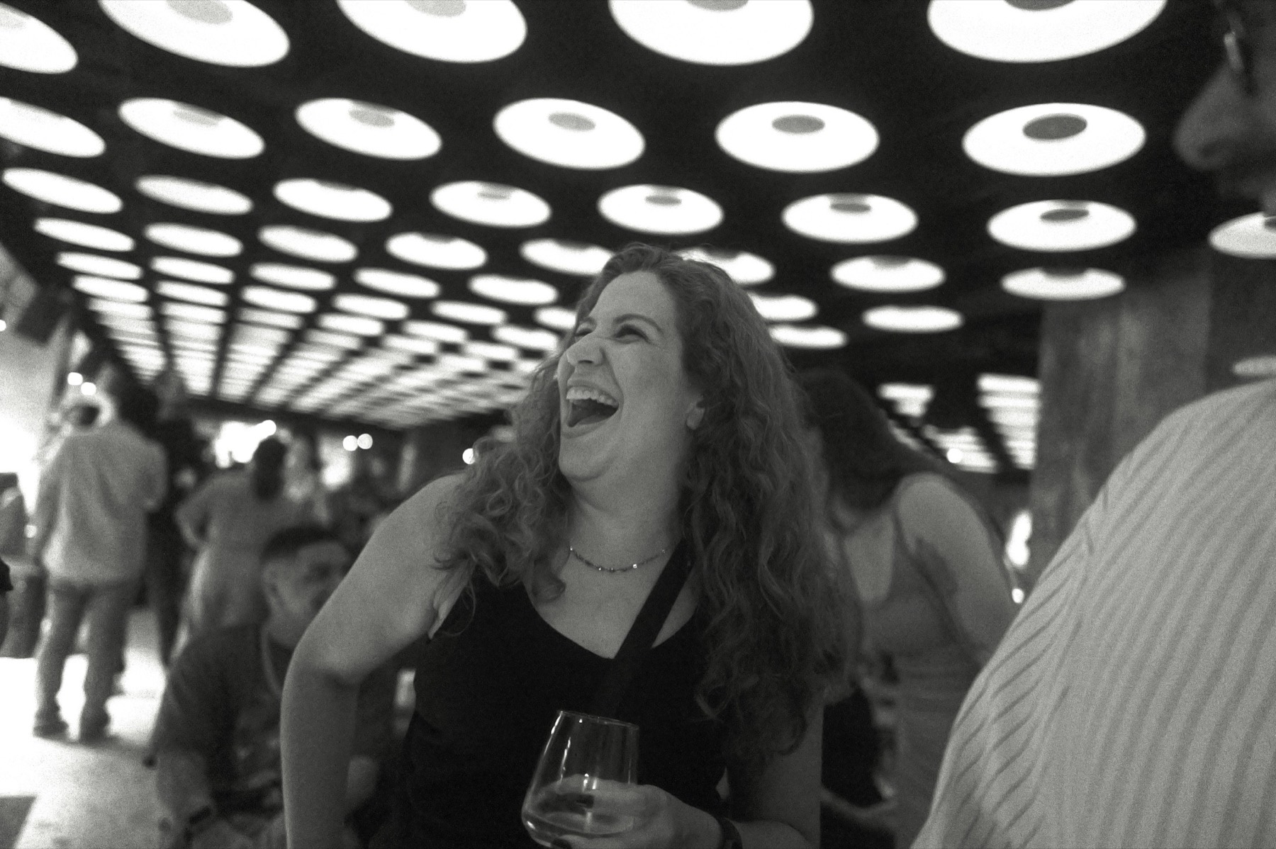 Laughter at a studio gathering under a ceiling of round lights